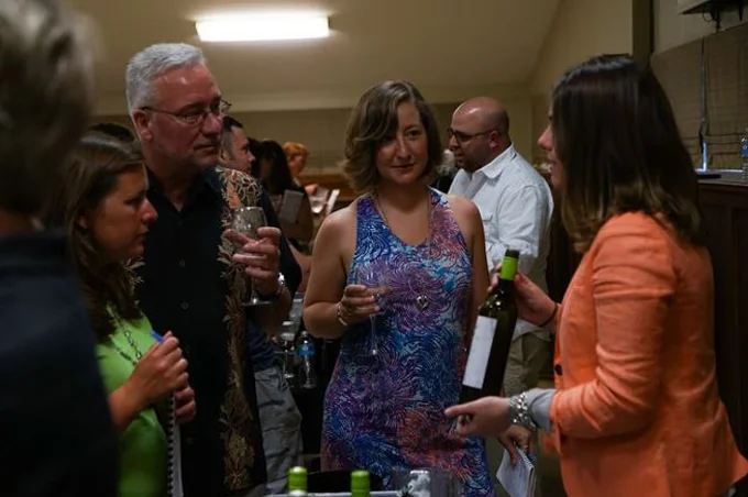 wine tasting attendees listening to wine vendor